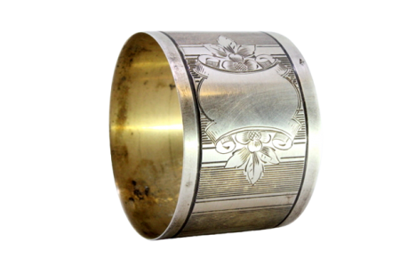 Argola de guardanapo em prata com bandas guilhochadas ao alto e motivos florais envolvendo cartela para monograma.